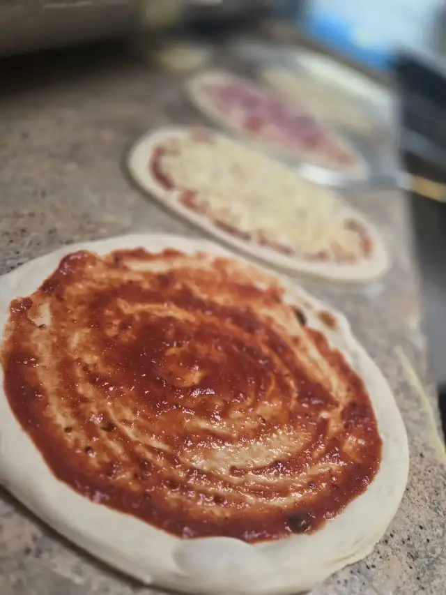 Empattage : la sauce tomate étalée sur la pâte
