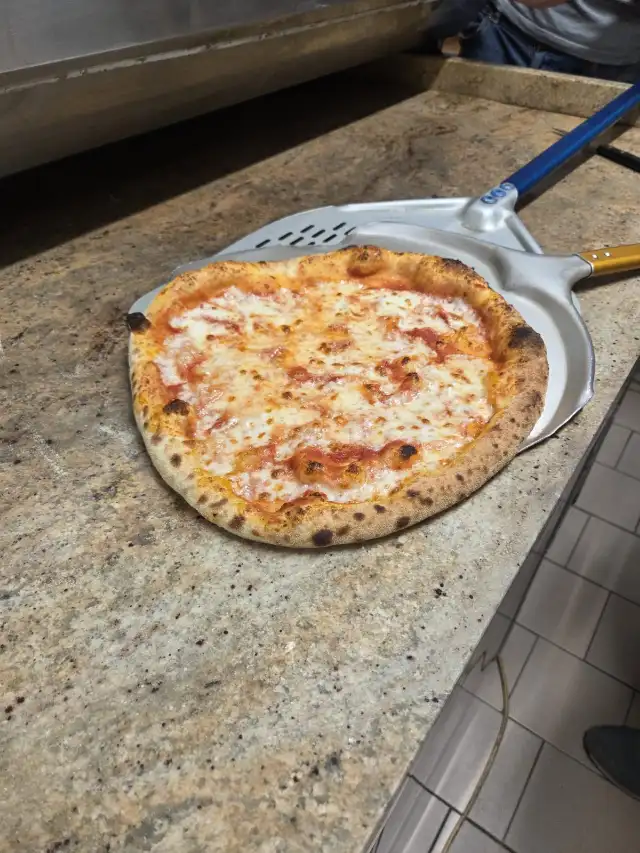 Pizza margherita à la sortie du four, sur la pelle