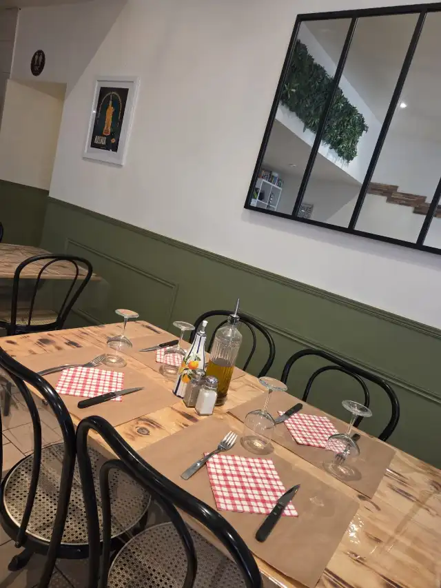 La salle du restaurant, tables dressées et boiseries vertes
